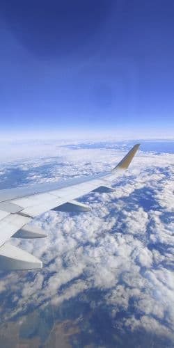 Vista desde la ventanilla del ala del avión sobre las nubes